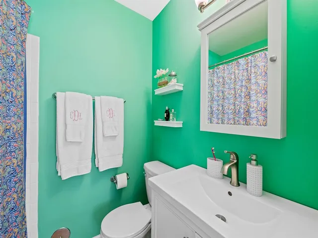 a bathroom with a sink mirror and a toilet