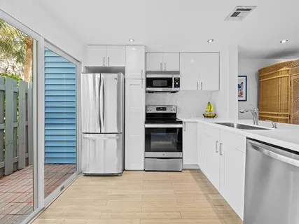 a kitchen with a refrigerator and a stove top oven