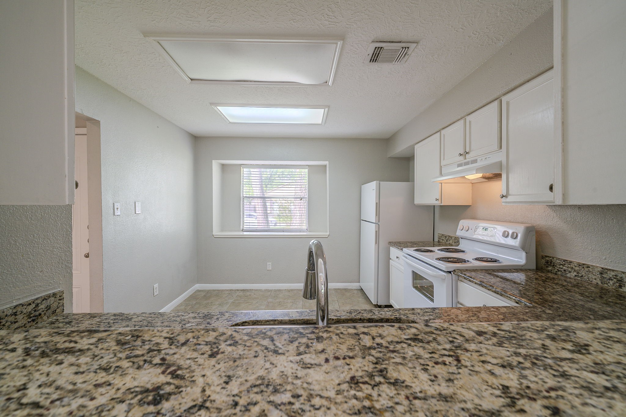 4127 Adonis Drive Spring, TX 77373 - Photo 5 of 20 a kitchen with granite countertop a stove a sink and a refrigerator