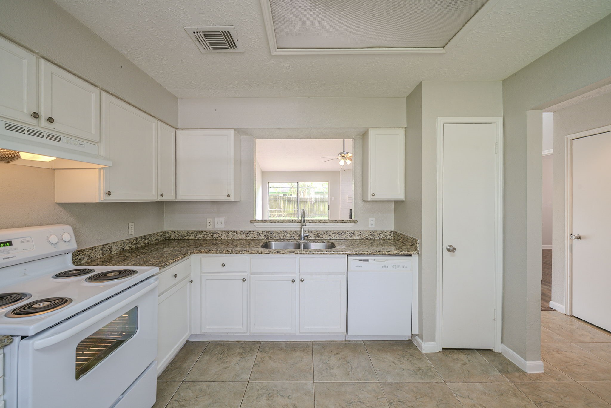 4127 Adonis Drive Spring, TX 77373 - Photo 7 of 20 a kitchen with granite countertop white cabinets and white appliances