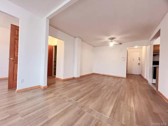 a view of empty room with wooden floor