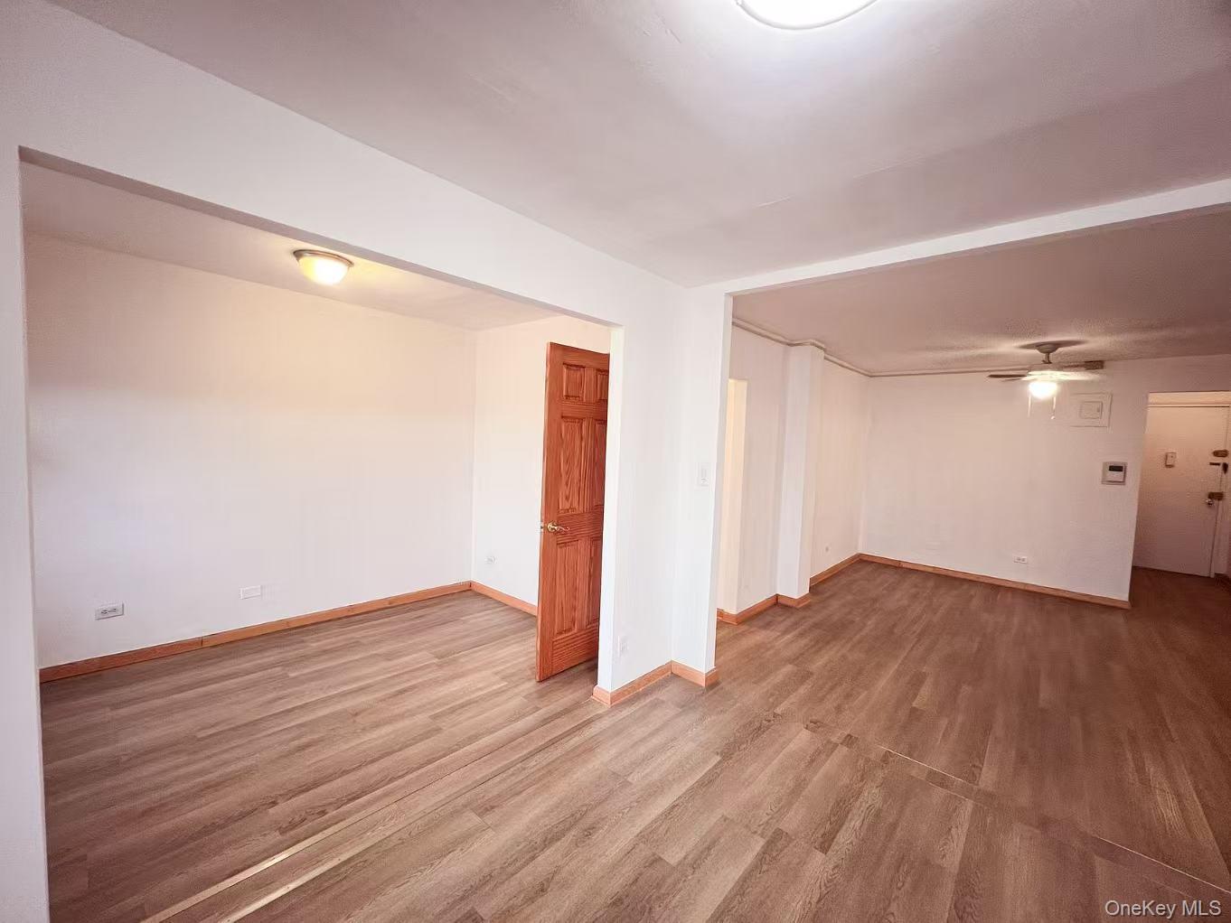 15272 Melbourne Avenue, Unit 3A Queens, NY 11367 - Photo 8 of 13 an empty room with wooden floor and windows