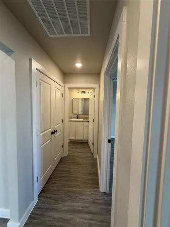 a view of a hallway with wooden floor