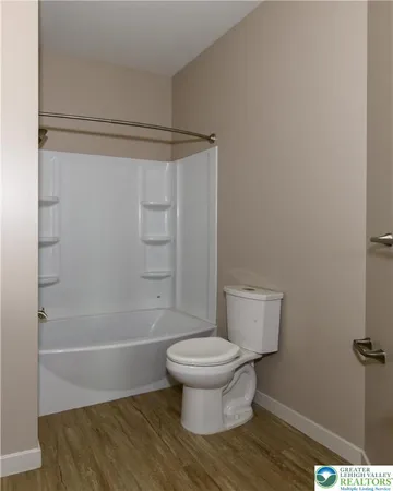 a bathroom with a toilet and a shower