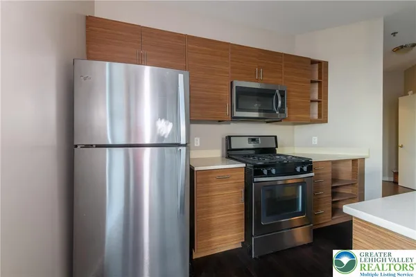 a kitchen with stainless steel appliances granite countertop a stove and a refrigerator