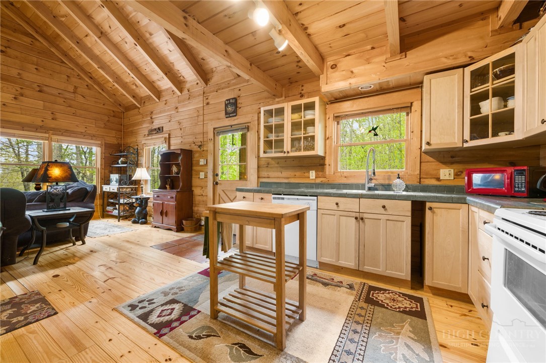 259 Greenbriar Road Beech Mountain, NC 28604 - Photo 10 of 41 a open kitchen with stainless steel appliances granite countertop a stove a sink dishwasher and cabinets with wooden floor