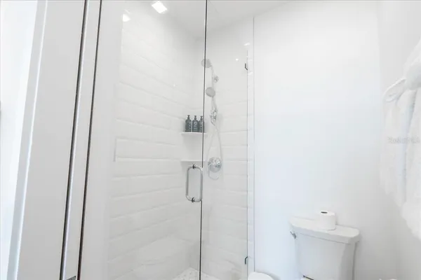 a large white bed sitting in a bedroom next to a window