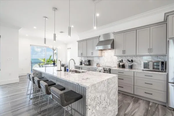 a kitchen with stainless steel appliances granite countertop a stove top oven a sink dishwasher and white cabinets with wooden floor