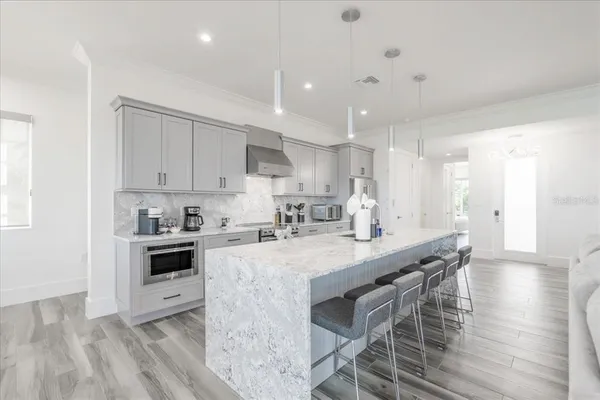 a view of a dining room with furniture a potted plant and wooden floor