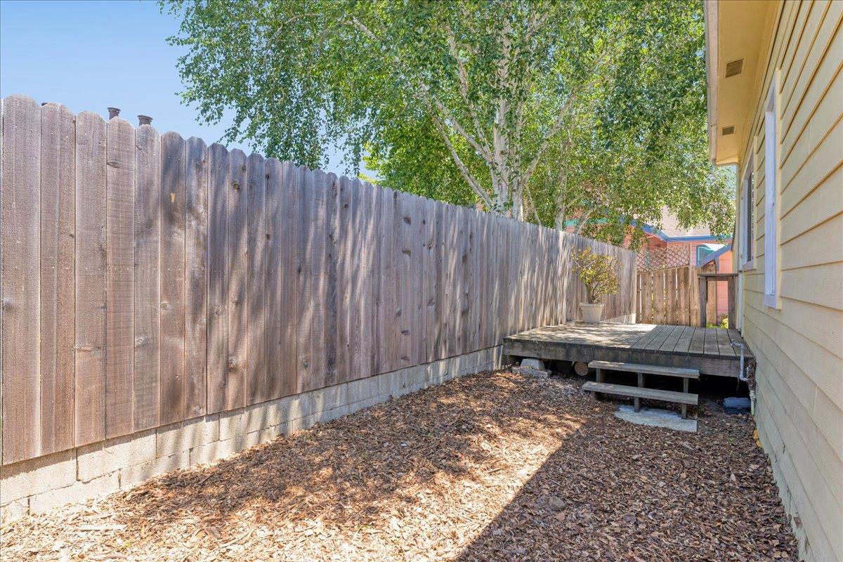 113 Fairbanks Street Santa Cruz, CA 95060 - Photo 24 of 27 a backyard of a house with lawn chairs and wooden fence