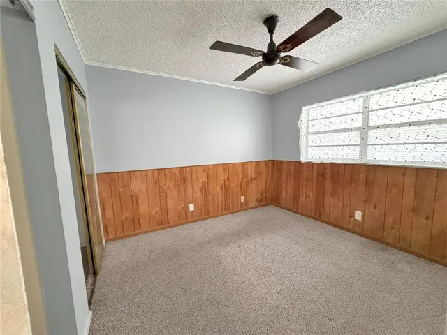 an empty room with a ceiling fan and window