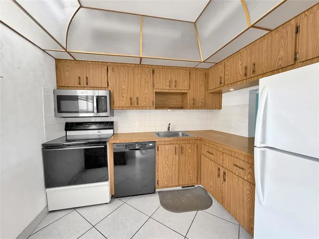 a kitchen with stainless steel appliances granite countertop a refrigerator sink and stove