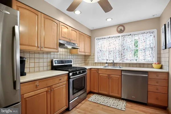 a kitchen with granite countertop stainless steel appliances a stove sink and cabinets
