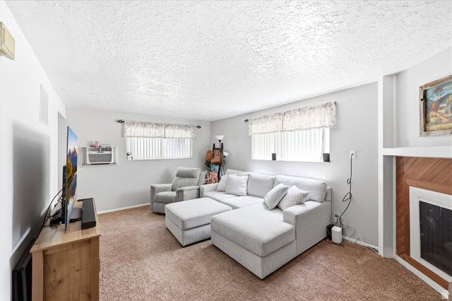 314 West Center Street, Unit F102 Bountiful, UT 84010 - Photo 9 of 29 Living area featuring light gray walls, textured ceiling, and brown carpet flooring