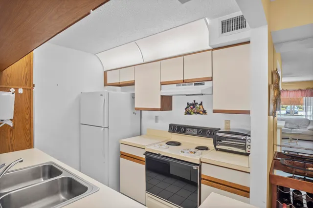 a kitchen with a white stove top oven and refrigerator