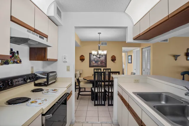 a kitchen with a sink a stove and chairs