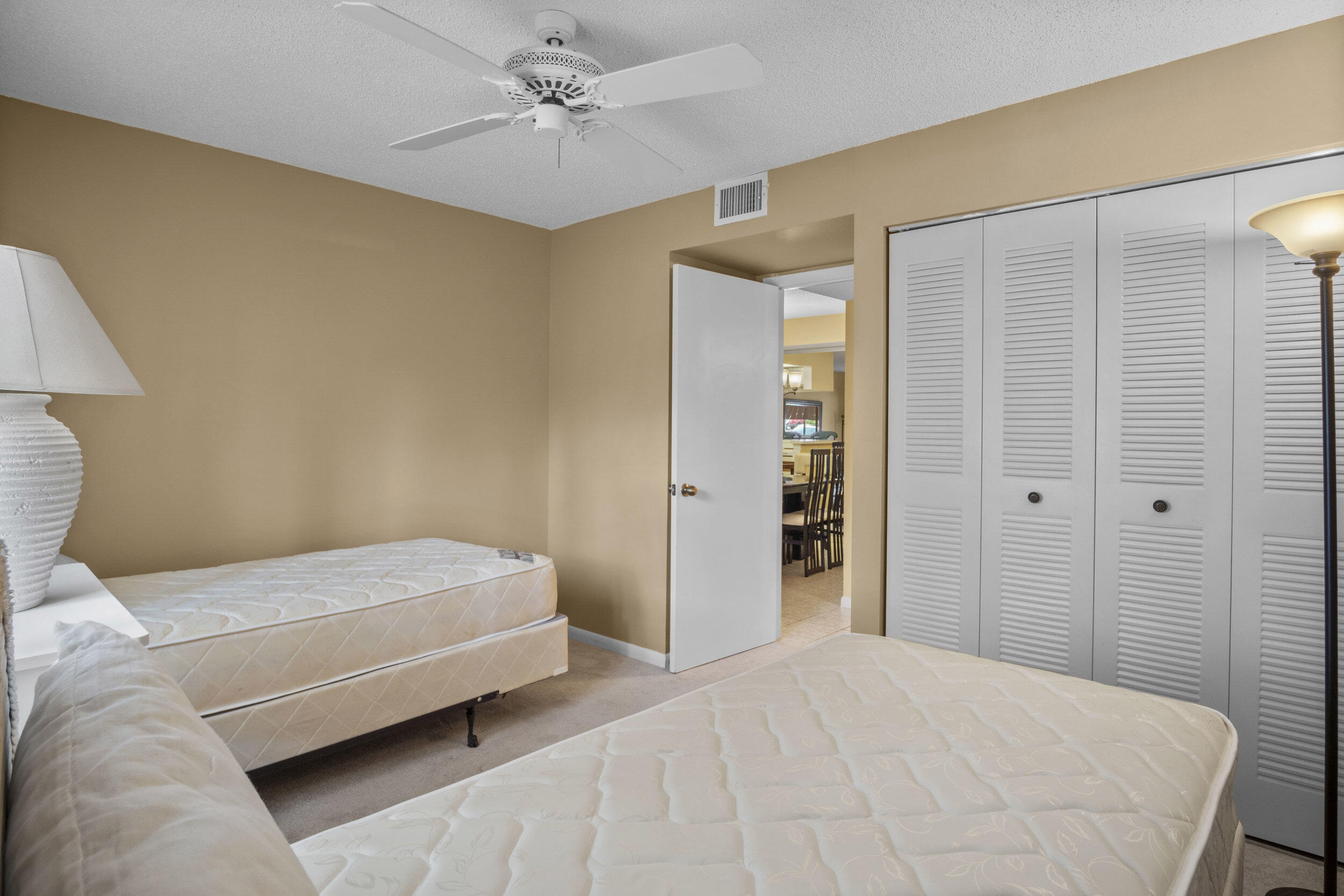 2512 Southeast Anchorage Cove, Unit B1 Port St. Lucie, FL 34952 - Photo 21 of 35 a bedroom with a bed closet and a lamp