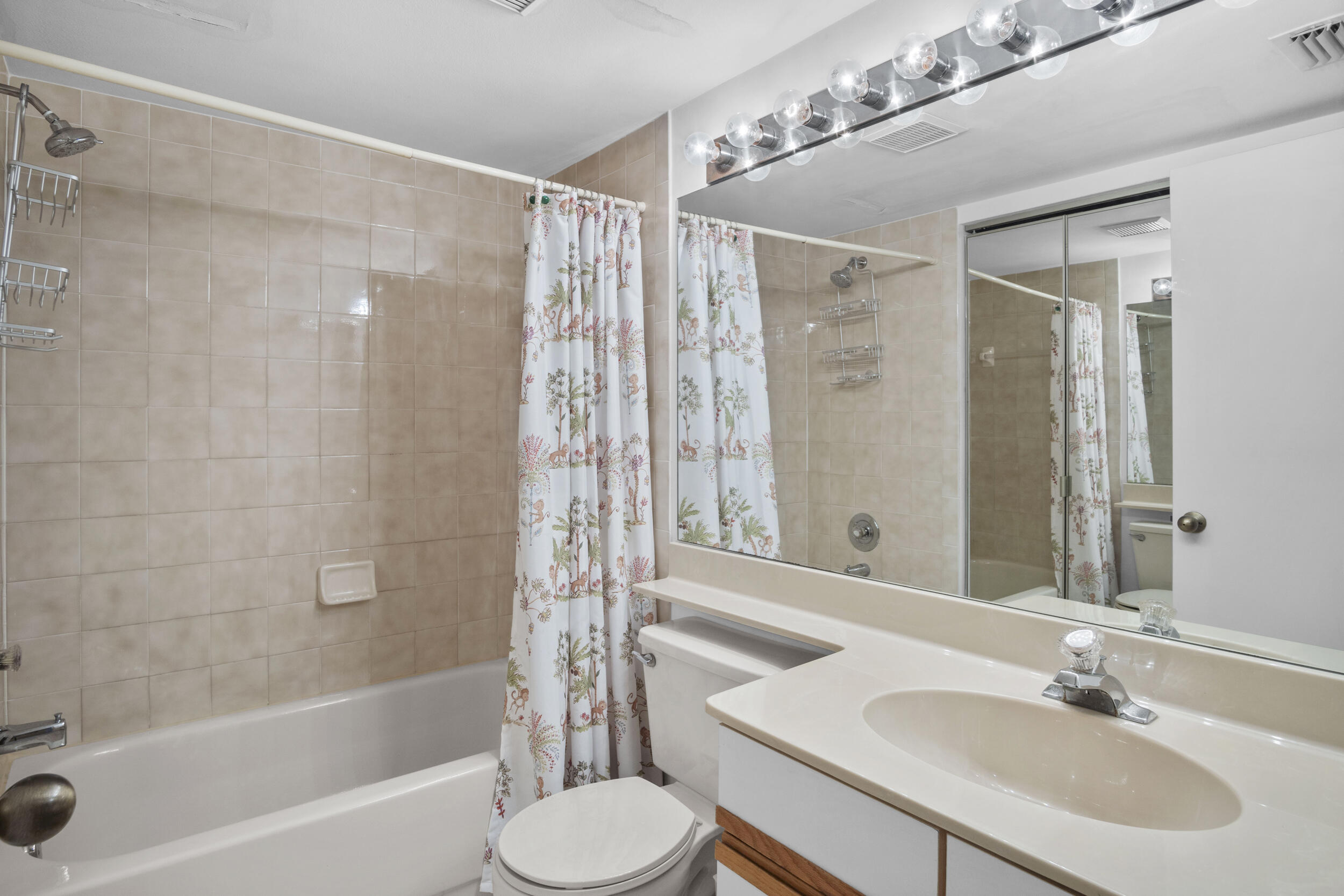 2512 Southeast Anchorage Cove, Unit B1 Port St. Lucie, FL 34952 - Photo 25 of 35 a bathroom with a sink toilet a shower and a mirror