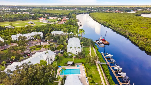 an aerial view of ocean and residential houses with outdoor space