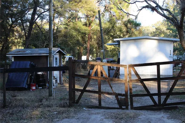 a view of a small house in middle of the forest