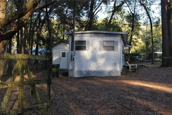a view of a house with backyard and trees