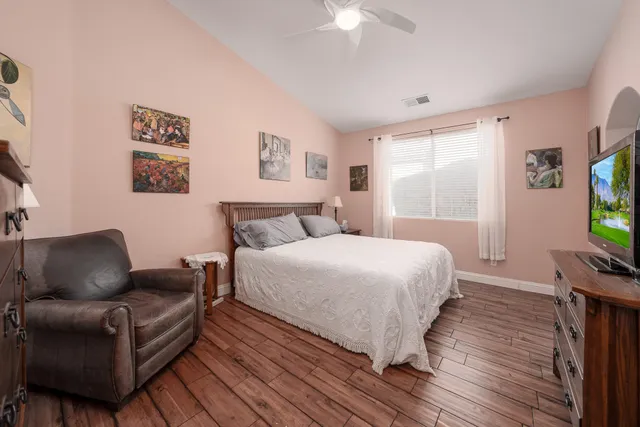 a bedroom with a bed couch and a flat screen tv