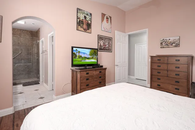 a bedroom with a bed and a flat screen tv