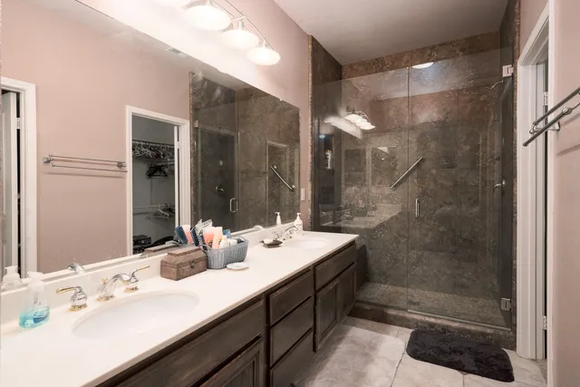 a bathroom with a double vanity sink mirror and shower