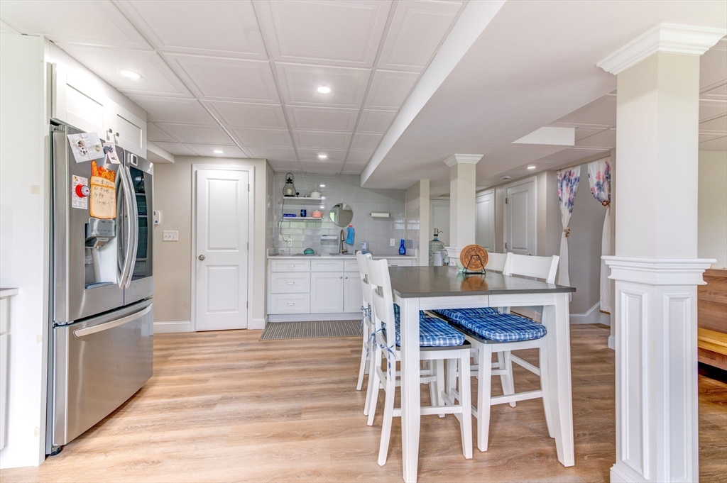 51 Tamarack Road Dracut, MA 01826 - Photo 26 of 39 a kitchen with stainless steel appliances kitchen island granite countertop a refrigerator a stove a microwave oven a dining table and chairs with wooden floor