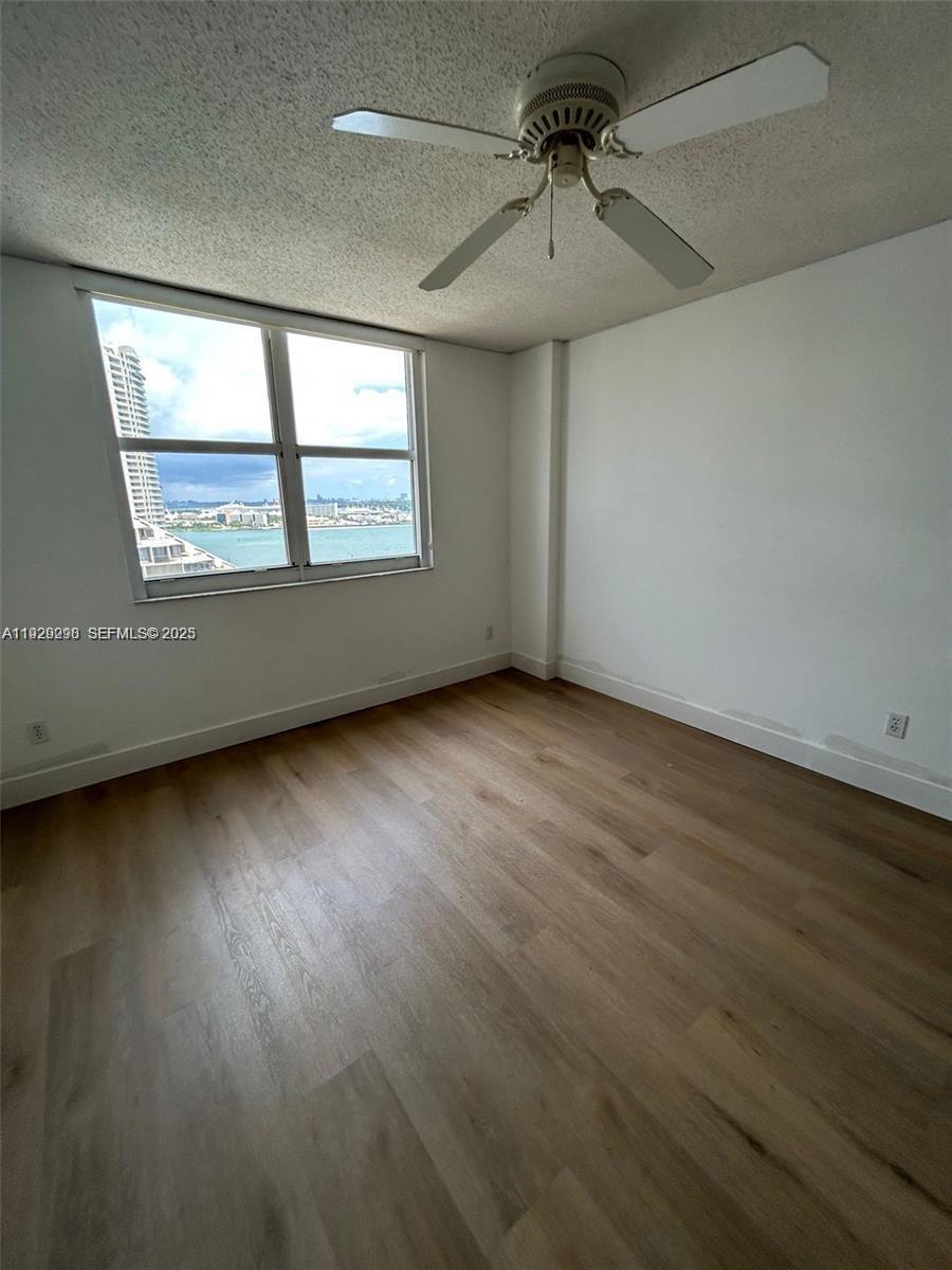 770 Claughton Island Drive, Unit 2109 Miami, FL 33131 - Photo 7 of 9 an empty room with wooden floor and windows