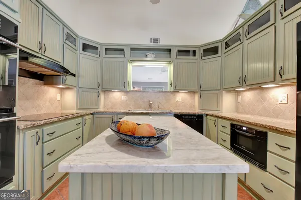 a view of a patio with table and chairs and floor to ceiling window