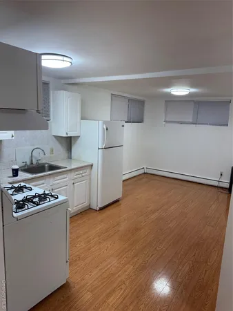 a kitchen with granite countertop a stove cabinets and wooden floor