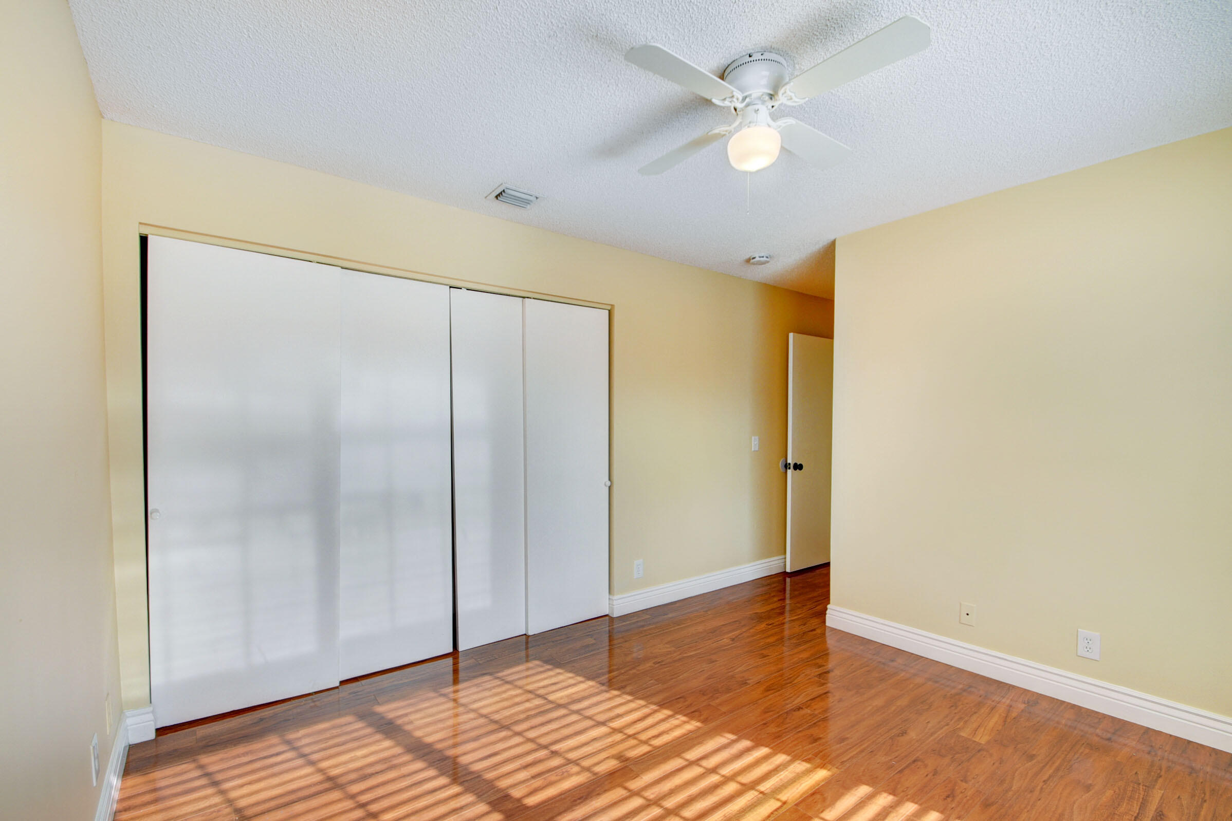 12561 Shoreside Lane Wellington, FL 33414 - Photo 18 of 31 a view of a room with wooden floor and a ceiling fan