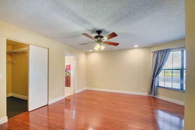a view of an empty room with window and wooden floor