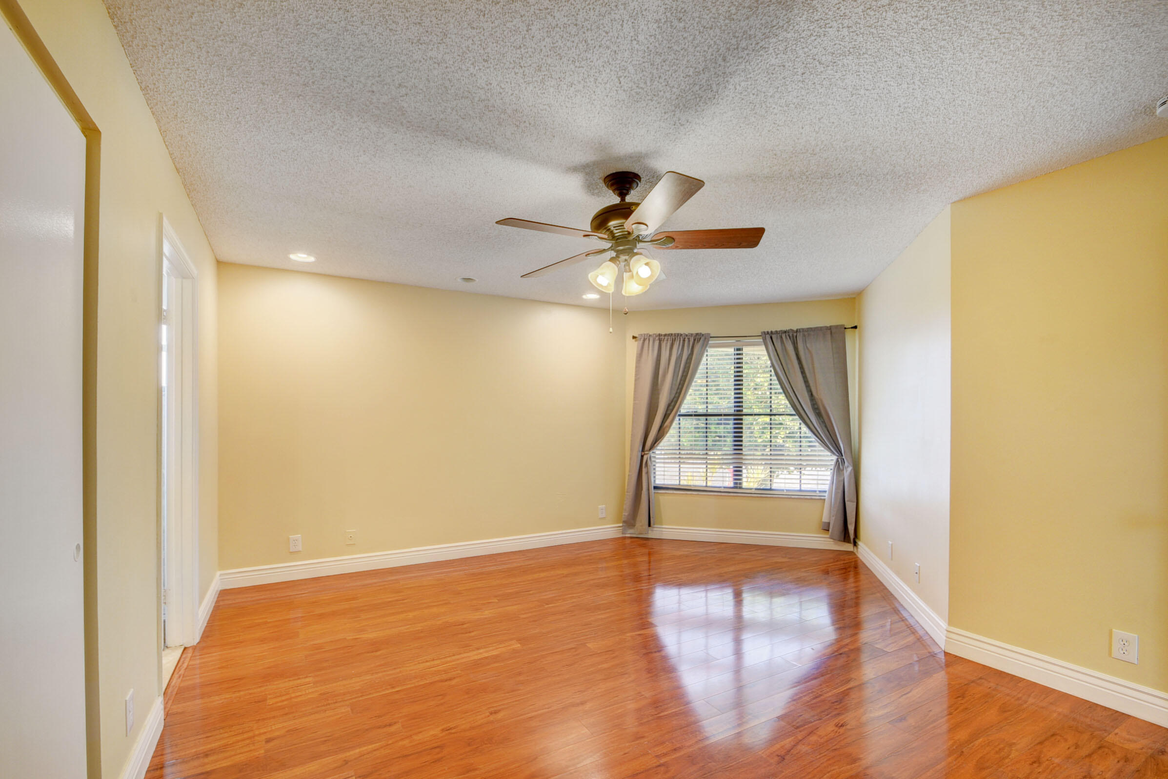 12561 Shoreside Lane Wellington, FL 33414 - Photo 22 of 31 an empty room with wooden floor and windows