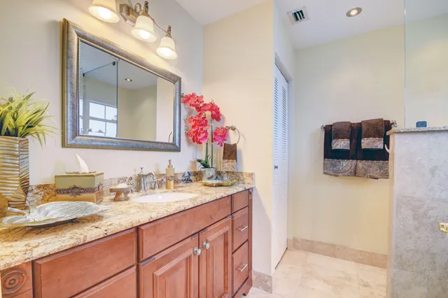a bathroom with a granite countertop double vanity sink and a mirror