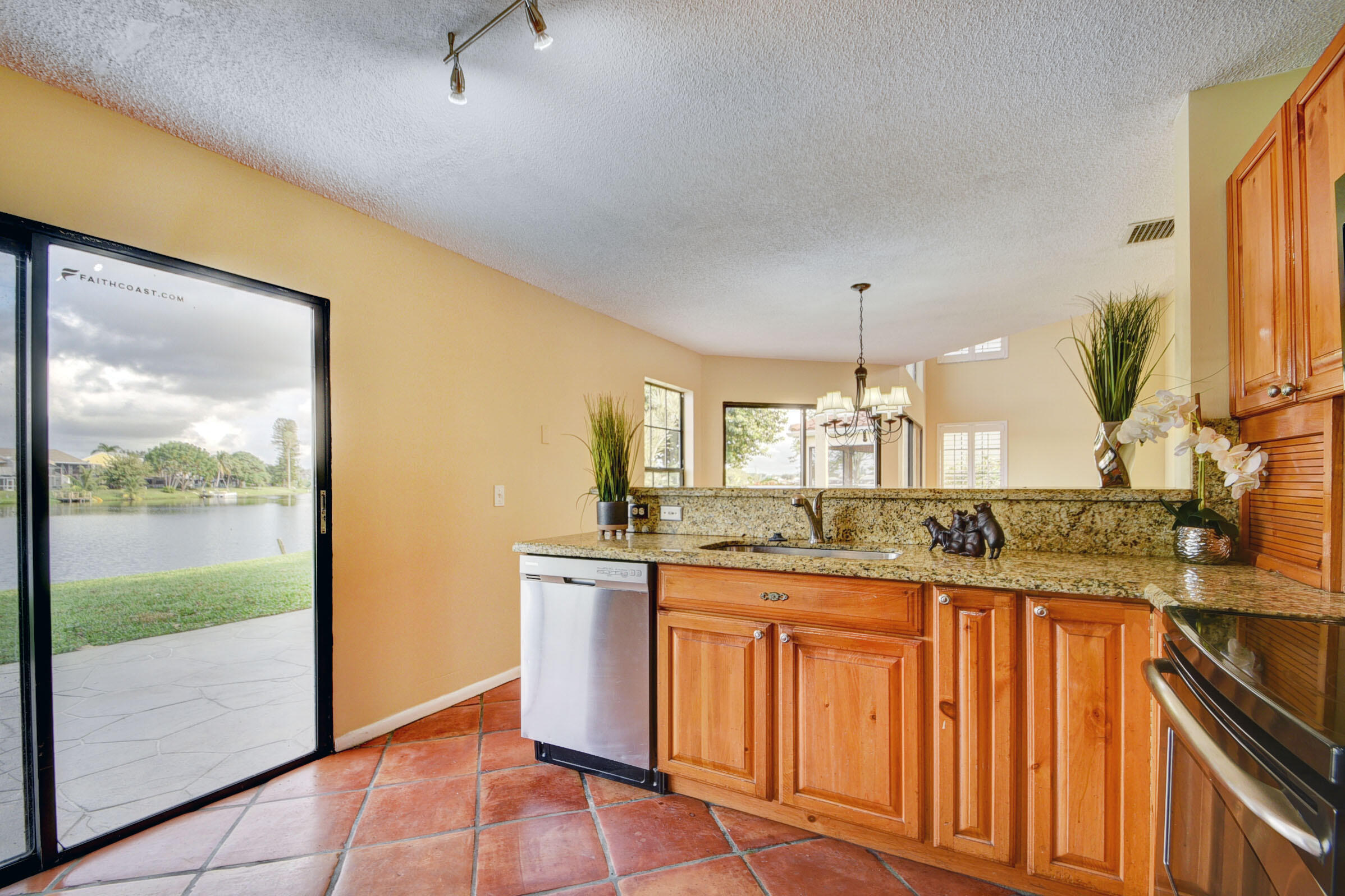 12561 Shoreside Lane Wellington, FL 33414 - Photo 5 of 31 a kitchen with granite countertop a sink and a refrigerator