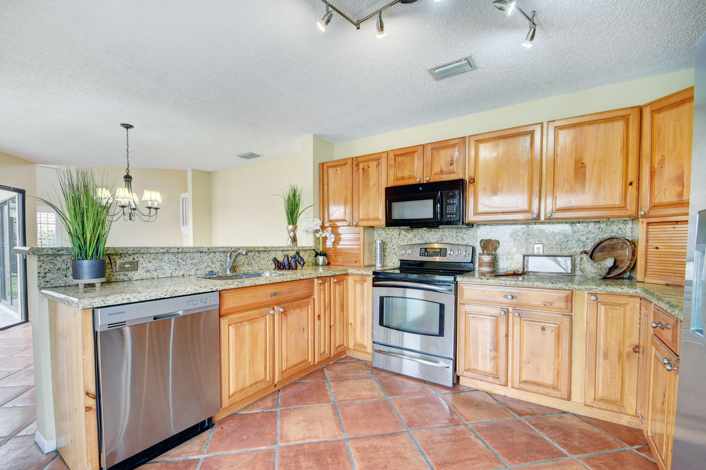 12561 Shoreside Lane Wellington, FL 33414 - Photo 6 of 31 a kitchen with stainless steel appliances granite countertop a stove a sink and a microwave