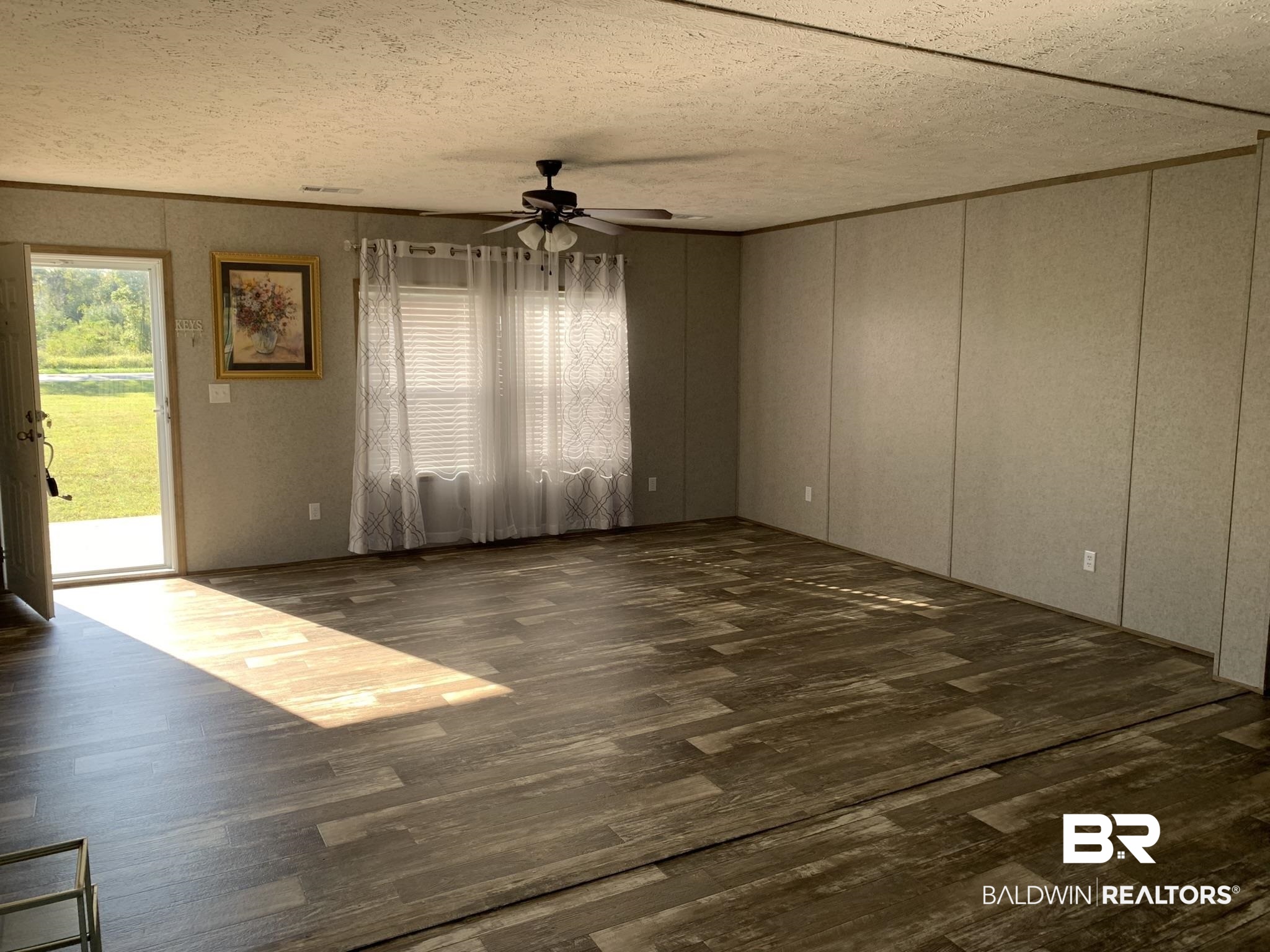 16876 County Road 87 Elberta, AL 36530 - Photo 7 of 13 Unfurnished room with a textured ceiling, dark wood-type flooring, and ceiling fan