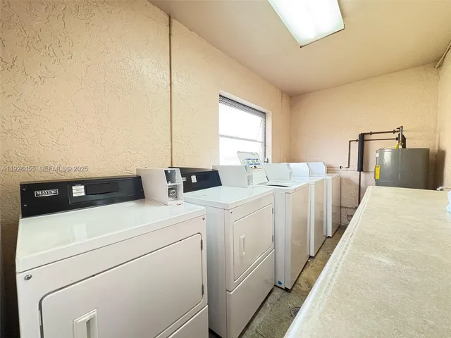 a view of washer and dryer with bathroom in the background