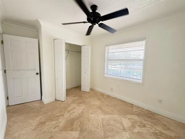 a view of an empty room and a ceiling fan