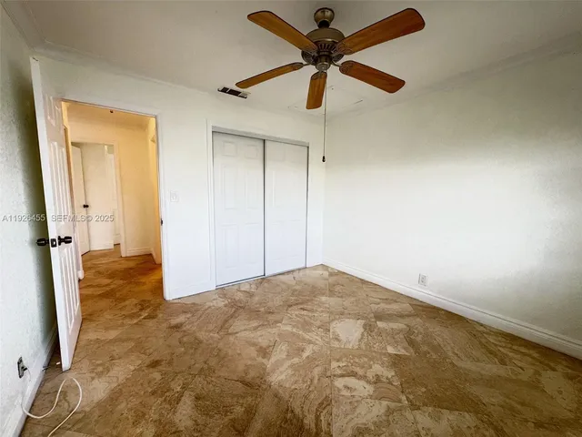 en empty room with a ceiling fan and a bathroom