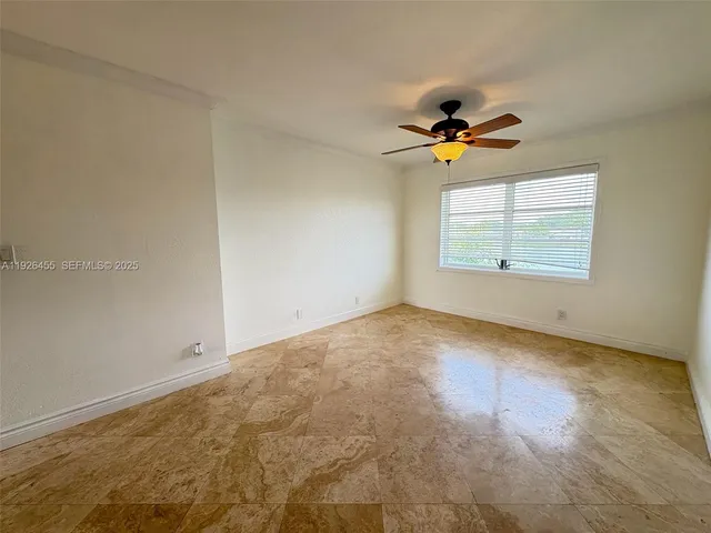 an empty room with windows and ceiling fan view
