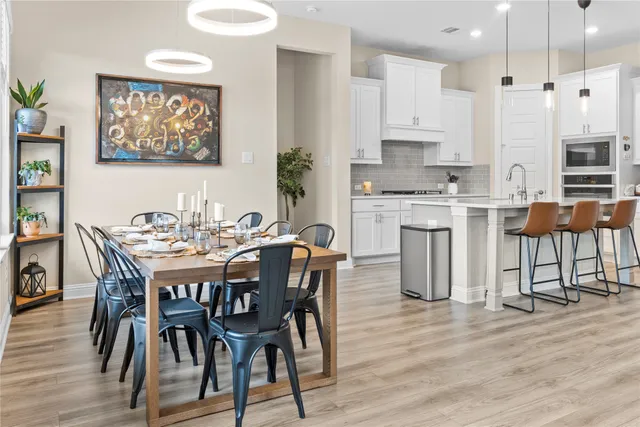 a open kitchen with stainless steel appliances granite countertop a stove top oven a refrigerator a sink and dishwasher with wooden floor