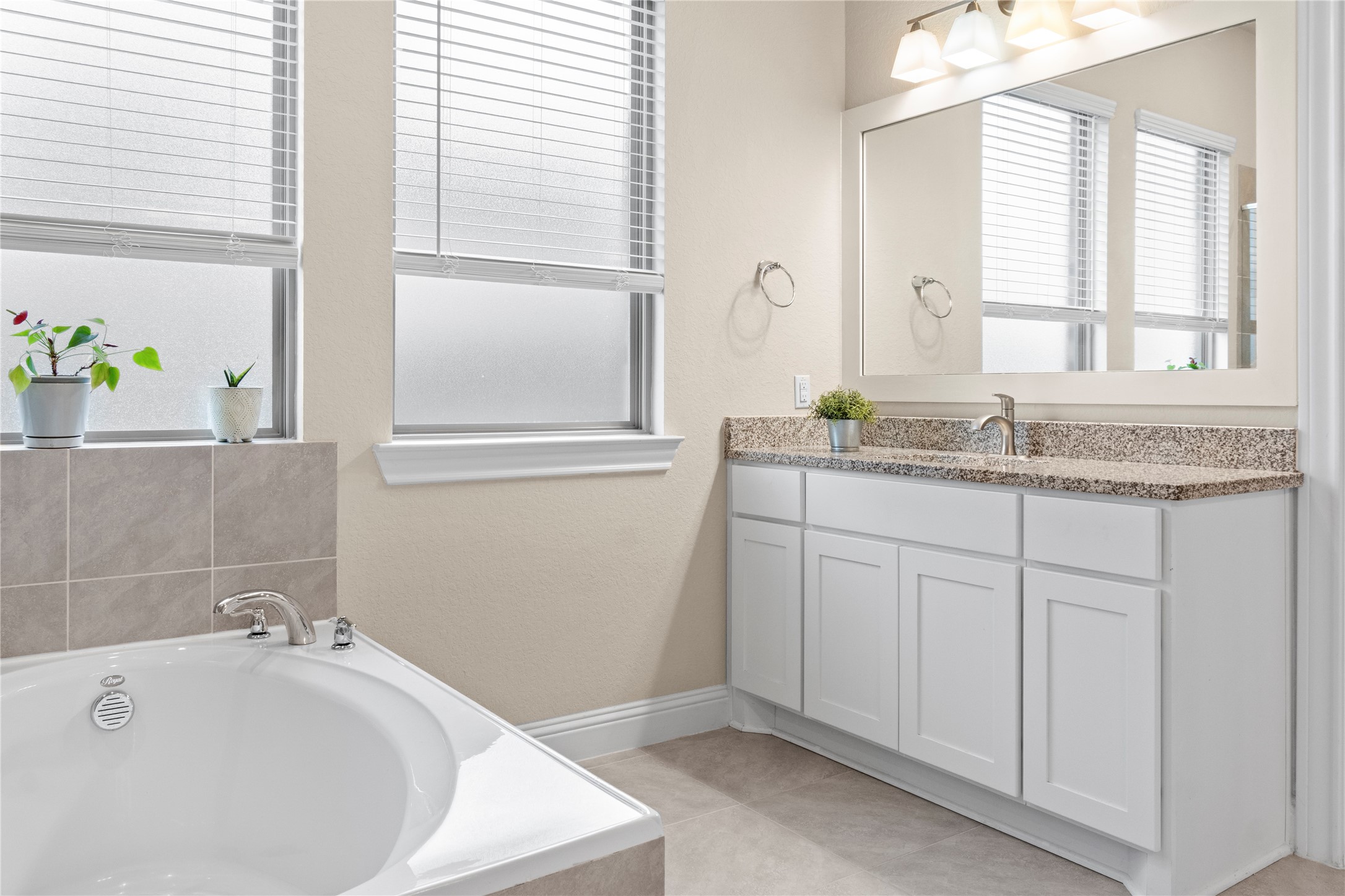 7518 Windsong Bend Road Spring, TX 77379 - Photo 25 of 49 a bathroom with a granite countertop sink and a bathtub