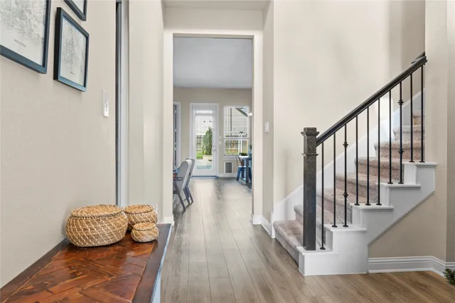 a view of a hallway with wooden floor and staircase