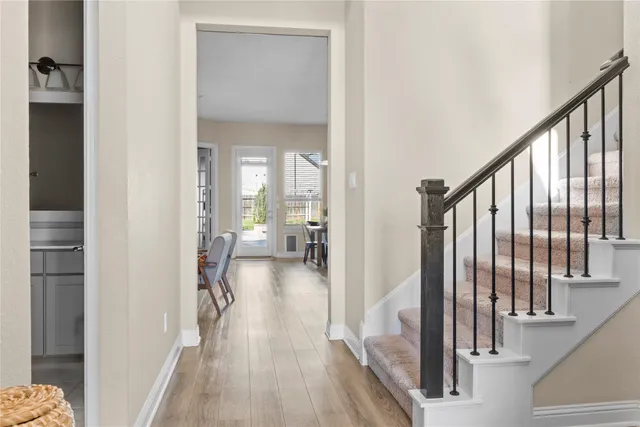 a living room with furniture floor to ceiling window hardwood floor and a flat screen tv