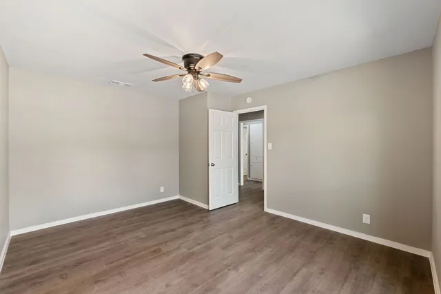 a view of room with wooden floor and ceiling fan