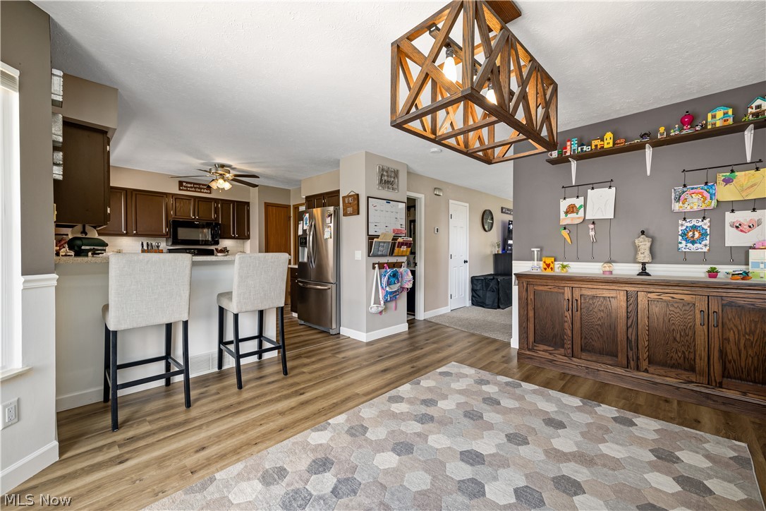 684 Guilford Road Vermilion, OH 44089 - Photo 10 of 37 Kitchen featuring light wood-type flooring, ceiling fan, kitchen peninsula, and stainless steel refrigerator with ice dispenser