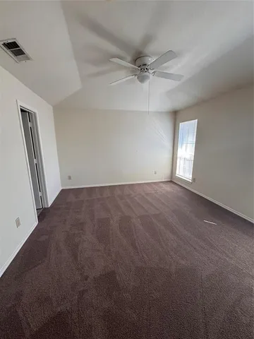 en empty room with windows and fan